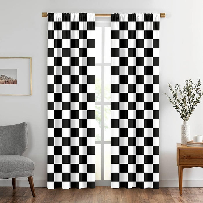 A pair of black and white checkered lamour satin curtains or drapery panels, displayed on a window in a room with minimalist decor.