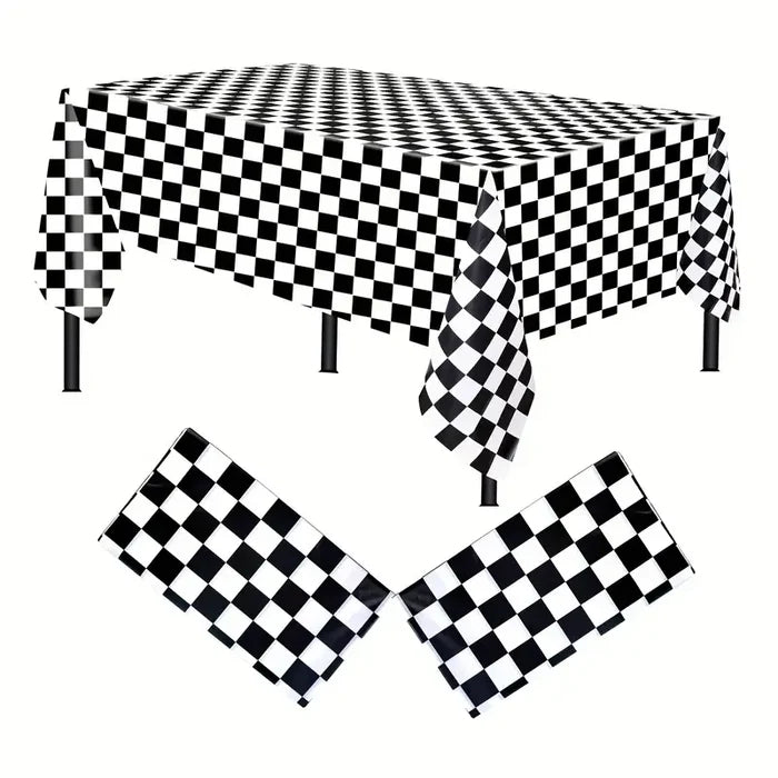 A checkered satin tablecloth in black and white, displayed on a table with a part of the tablecloth folded to show the fabric's texture.
